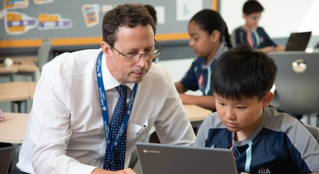 صورة تتضمن مدرس يعلم طالب وهي مرفقة لمقال ينشر فرص عمل للمدرسين في الامارات بمدرسة أسبن هايتس