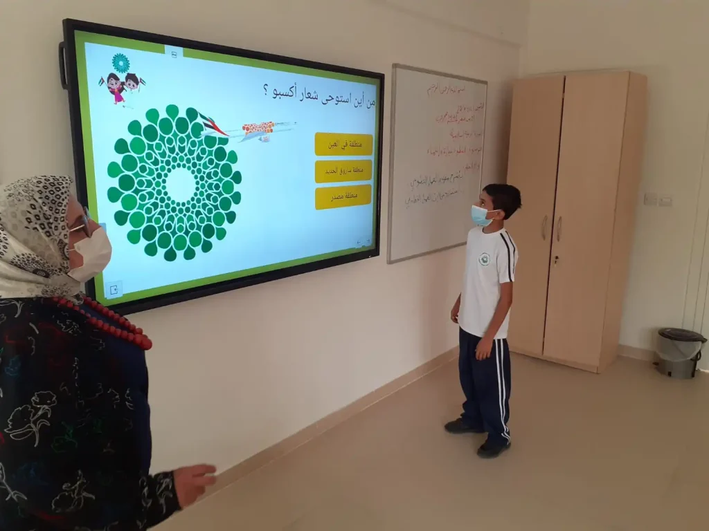 صورة توضح طالب ومدرسة في مدرسة السدرة العالمية وهي مرقة مع إعلان وظيفي حول شواغر تدريس وفرص عمل في الامارات